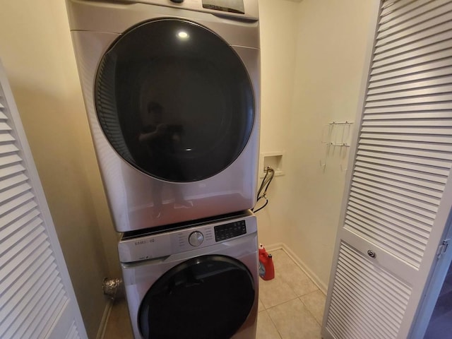 3041 W Pope John Paul Ii Dr, Chicago, IL 60638 - laundry room with stacked washer and clothes dryer, light tile patterned floors, and baseboards