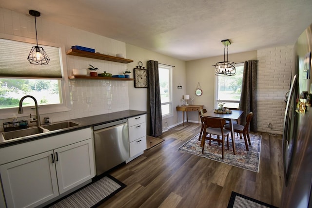401 W Boundary St, Stanford, IL 61774 - kitchen with stainless steel dishwasher, a sink, dark countertops, dark wood-style floors, and tasteful backsplash
