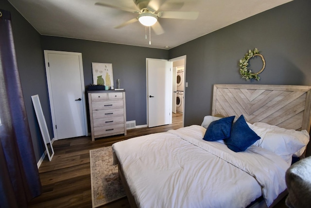 401 W Boundary St, Stanford, IL 61774 - bedroom featuring stacked washer / drying machine, dark wood finished floors, baseboards, and ceiling fan