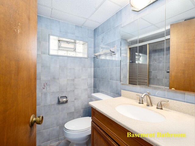 6005 N Canfield Ave, Chicago, IL 60631 - bathroom featuring toilet, vanity, tile walls, and a drop ceiling