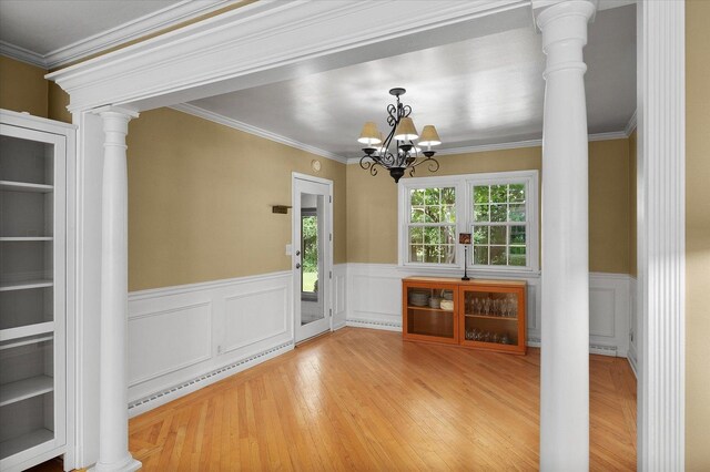 603 Shabbona Trl, Batavia, IL 60510 - unfurnished dining area with decorative columns, wainscoting, wood finished floors, crown molding, and a chandelier