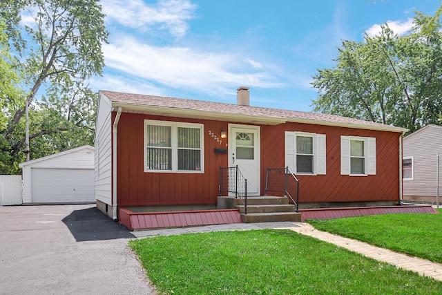 22227 Clyde Ave, Sauk Village, IL 60411 - view of front facade featuring a garage, an outdoor structure, a chimney, and a front yard