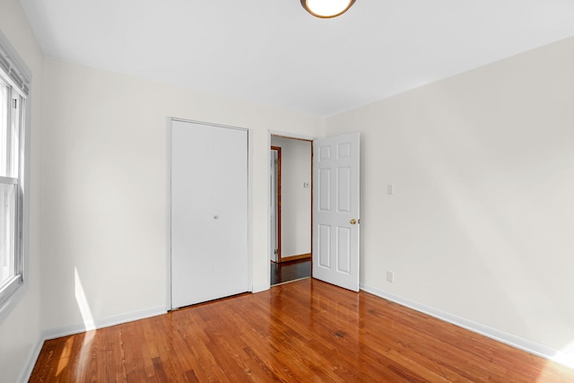 22227 Clyde Ave, Sauk Village, IL 60411 - unfurnished bedroom with wood finished floors and a closet