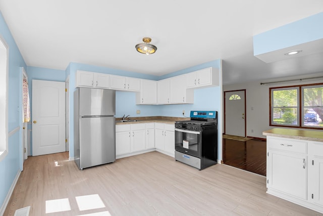 22227 Clyde Ave, Sauk Village, IL 60411 - kitchen featuring appliances with stainless steel finishes, light wood finished floors, and white cabinets
