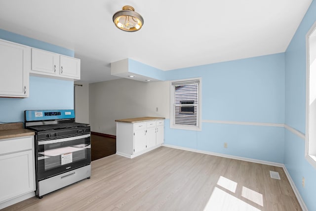 22227 Clyde Ave, Sauk Village, IL 60411 - kitchen featuring gas range, light wood finished floors, and white cabinetry