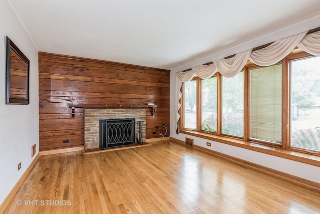945 S Wolf Rd, Des Plaines, IL 60016 - unfurnished living room featuring a fireplace, light wood-style flooring, and wooden walls