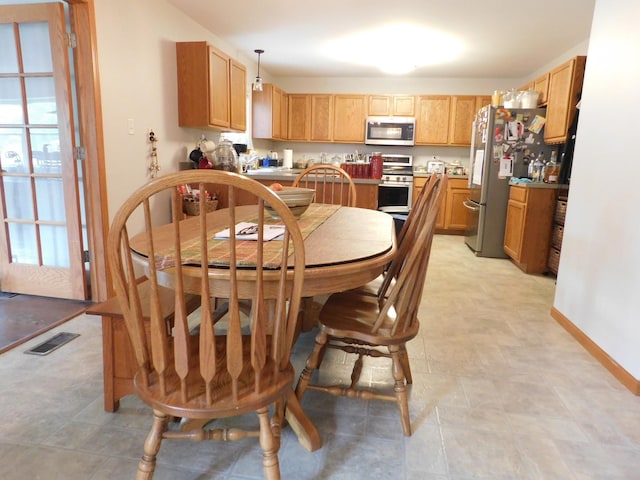 1064 N 129th Infantry Dr, Joliet, IL 60435 - kitchen with stainless steel appliances, baseboards, and hanging light fixtures