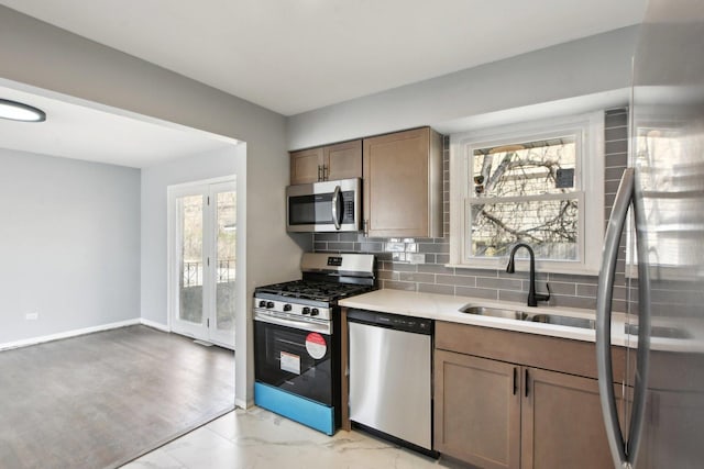 1848 172nd St, East Hazel Crest, IL 60429 - kitchen with appliances with stainless steel finishes, light countertops, decorative backsplash, light marble finish flooring, and baseboards