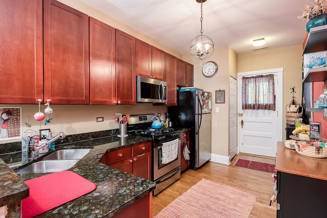 206 S Lombard Ave Unit 206B, Oak Park, IL 60302 - kitchen featuring stainless steel appliances, light wood-style floors, hanging light fixtures, dark stone counters, and a chandelier