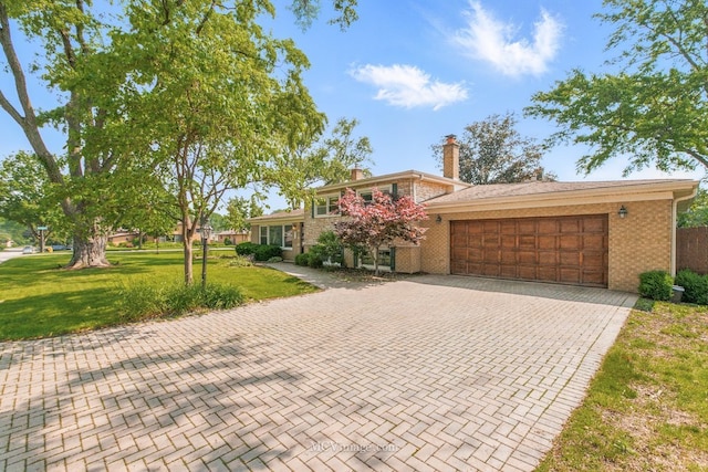 1703 Wilmette St, Wheaton, IL 60187 - tri-level home with an attached garage, decorative driveway, brick siding, a front lawn, and a chimney