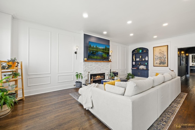 7321 S S Shore Dr Unit 10A, Chicago, IL 60649 - living area featuring a decorative wall, built in shelves, ornamental molding, a stone fireplace, and dark wood-style floors