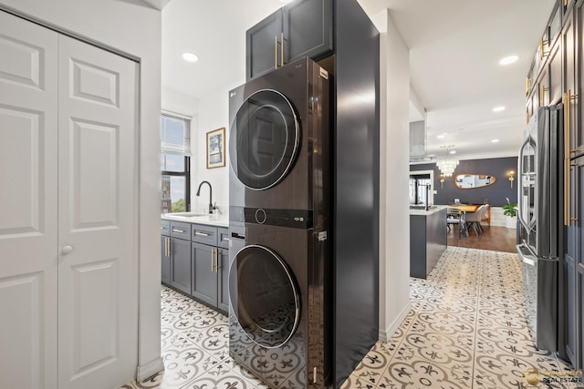 7321 S S Shore Dr Unit 10A, Chicago, IL 60649 - laundry area featuring stacked washer / drying machine, healthy amount of natural light, a chandelier, recessed lighting, and light tile patterned flooring