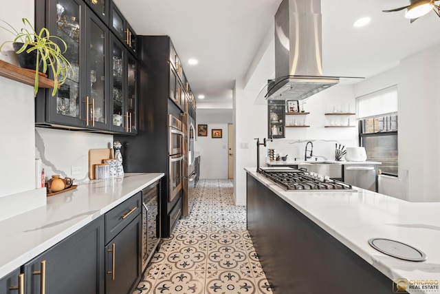 7321 S S Shore Dr Unit 10A, Chicago, IL 60649 - kitchen featuring appliances with stainless steel finishes, island range hood, recessed lighting, glass insert cabinets, and light stone countertops