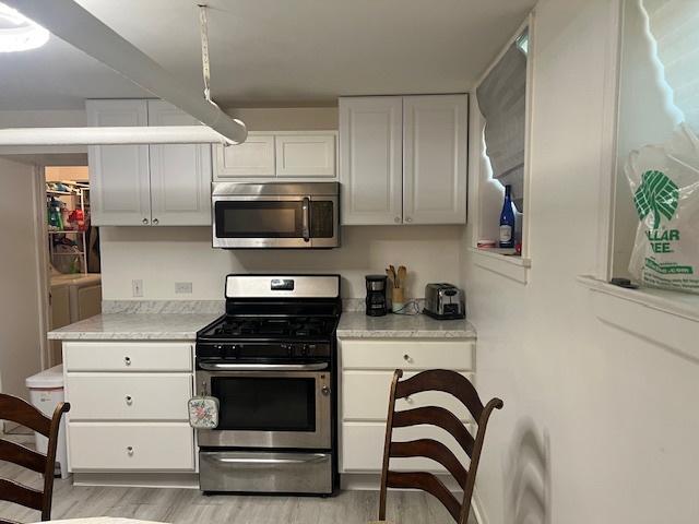 1359 W Elmdale Ave Unit G, Chicago, IL 60660 - kitchen with appliances with stainless steel finishes, light wood finished floors, light countertops, and white cabinetry