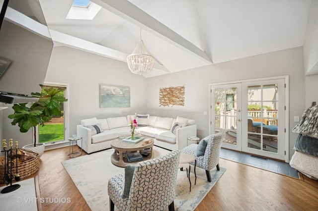 503 Oakdale Ave, Glencoe, IL 60022 - living room with a chandelier, wood finished floors, french doors, a skylight, and high vaulted ceiling