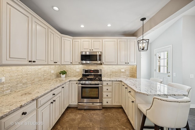 503 Oakdale Ave, Glencoe, IL 60022 - kitchen featuring appliances with stainless steel finishes, a peninsula, a chandelier, a kitchen breakfast bar, and backsplash
