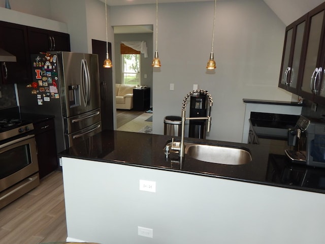 355 Wentworth Ln, Bartlett, IL 60103 - kitchen with stainless steel gas stove, dark countertops, light wood-style floors, vaulted ceiling, and a peninsula