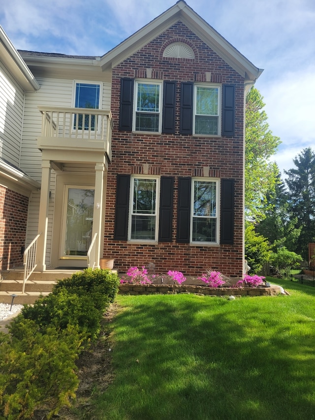 355 Wentworth Ln, Bartlett, IL 60103 - view of front facade featuring brick siding, a balcony, and a front lawn