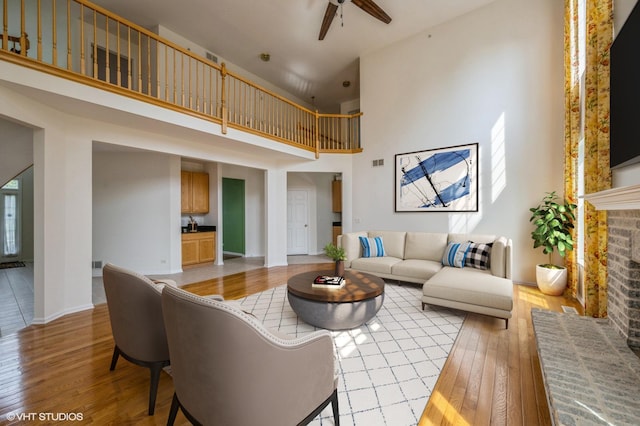 5436 Swan Cir, Hoffman Estates, IL 60192 - living room with light wood-style floors, a towering ceiling, a ceiling fan, and a fireplace