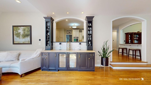 2515 Thurston Ct, Aurora, IL 60502 - bar featuring recessed lighting, oven, light wood-type flooring, tasteful backsplash, and arched walkways