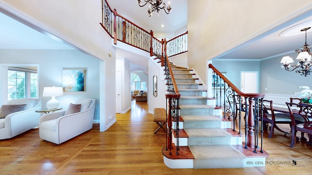 2515 Thurston Ct, Aurora, IL 60502 - staircase featuring a chandelier, wood finished floors, crown molding, arched walkways, and a high ceiling