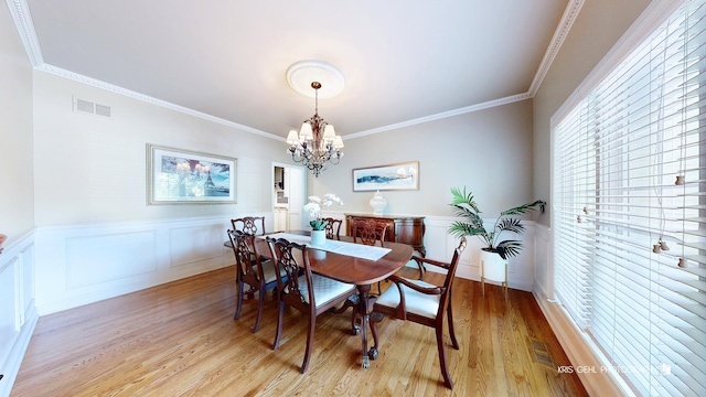 2515 Thurston Ct, Aurora, IL 60502 - dining space with a chandelier, light wood finished floors, ornamental molding, wainscoting, and a decorative wall