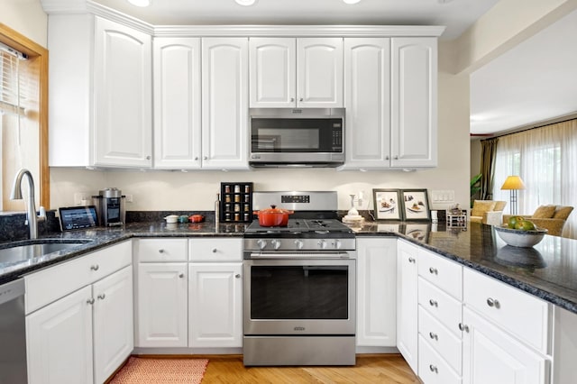 5055 N California Ave Unit 1S, Chicago, IL 60625 - kitchen with appliances with stainless steel finishes, white cabinets, and light wood-style floors