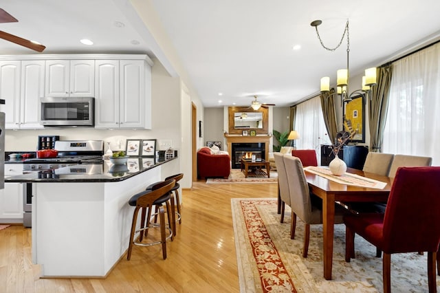 5055 N California Ave Unit 1S, Chicago, IL 60625 - dining area with ceiling fan, a glass covered fireplace, light wood-style floors, and recessed lighting