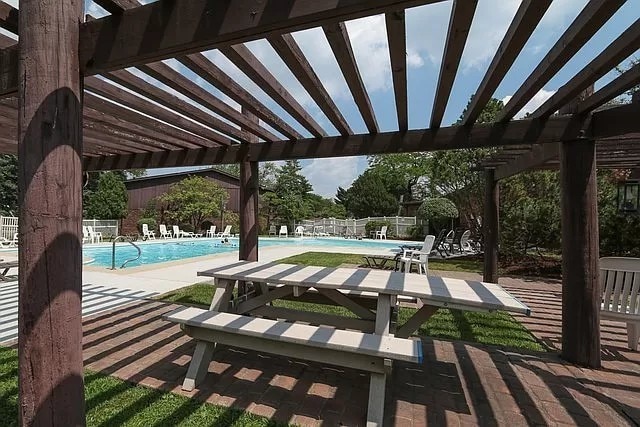 47 Pier Dr Unit 102, Westmont, IL 60559 - fenced backyard with a pergola, a community pool, and a patio area