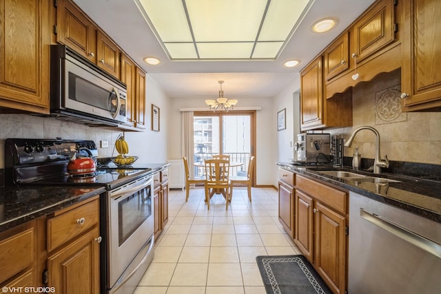 1380 Oakwood Ave Unit 306, Des Plaines, IL 60016 - kitchen with stainless steel appliances, a sink, a chandelier, brown cabinets, and decorative backsplash