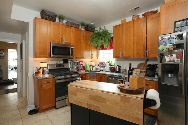 401 N Humphrey Ave, Oak Park, IL 60302 - kitchen with appliances with stainless steel finishes, brown cabinets, and light tile patterned flooring