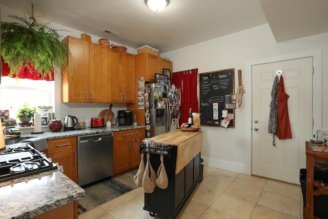 401 N Humphrey Ave, Oak Park, IL 60302 - kitchen with appliances with stainless steel finishes, brown cabinets, light tile patterned floors, and light stone counters
