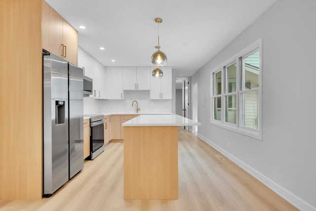 18624 W Pamela Pl, Gurnee, IL 60031 - kitchen with stainless steel appliances, light countertops, light wood-style floors, hanging light fixtures, and a center island