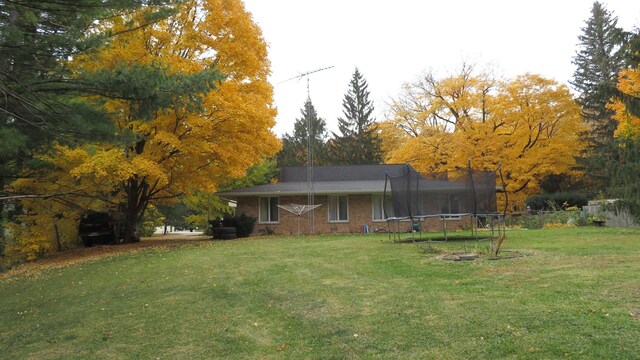 42W490 Kedeka Rd, Sugar Grove, IL 60554 - back of property with a trampoline, brick siding, and view of scattered trees