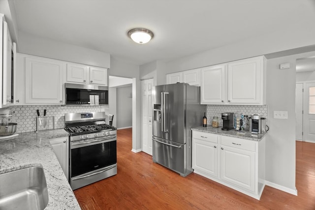 2003 Schumacher Dr, Naperville, IL 60540 - kitchen with appliances with stainless steel finishes, tasteful backsplash, light wood finished floors, white cabinets, and light stone countertops