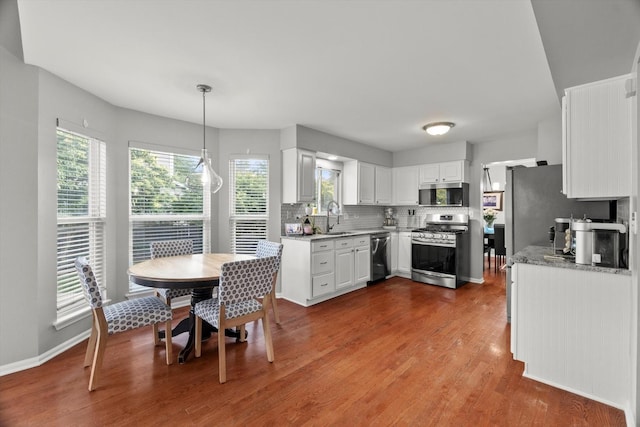 2003 Schumacher Dr, Naperville, IL 60540 - kitchen featuring stainless steel appliances, tasteful backsplash, dark wood finished floors, white cabinetry, and pendant lighting