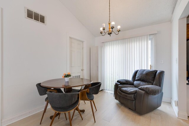 91 Rockledge Dr, Romeoville, IL 60446 - dining room with light wood-style floors, a chandelier, and vaulted ceiling
