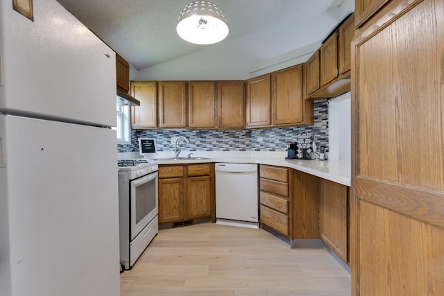 91 Rockledge Dr, Romeoville, IL 60446 - kitchen featuring white appliances, brown cabinetry, light wood-type flooring, backsplash, and lofted ceiling