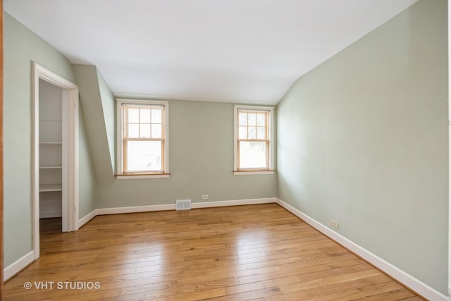 1707 N 78th Ave, Elmwood Park, IL 60707 - unfurnished room featuring light wood finished floors, lofted ceiling, and healthy amount of natural light