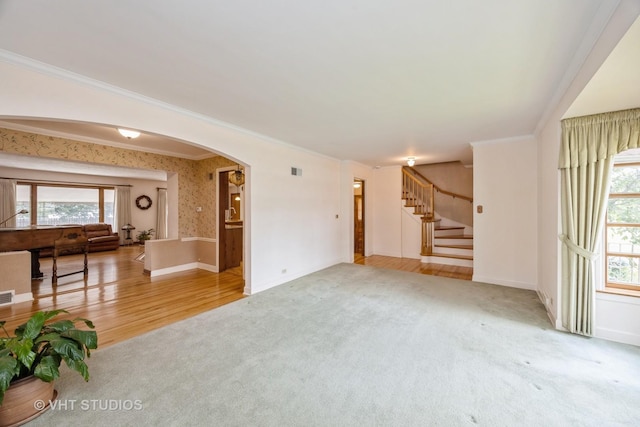 1707 N 78th Ave, Elmwood Park, IL 60707 - unfurnished living room featuring carpet, plenty of natural light, arched walkways, stairs, and ornamental molding