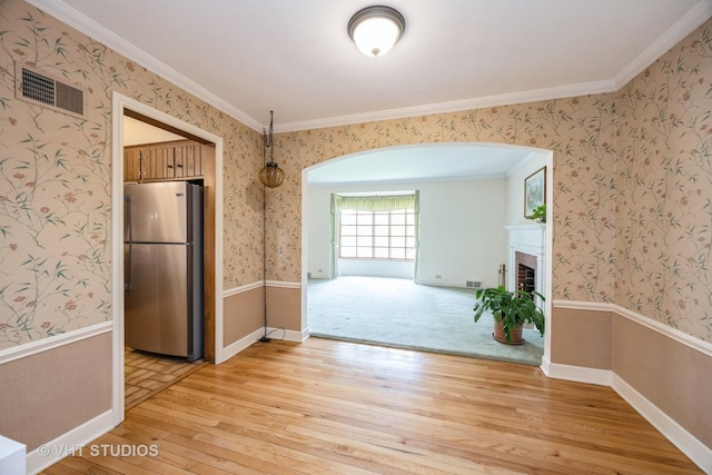 1707 N 78th Ave, Elmwood Park, IL 60707 - unfurnished dining area featuring light wood-style flooring, arched walkways, wallpapered walls, a brick fireplace, and ornamental molding