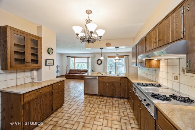 1707 N 78th Ave, Elmwood Park, IL 60707 - kitchen with stainless steel dishwasher, under cabinet range hood, a peninsula, and brown cabinets