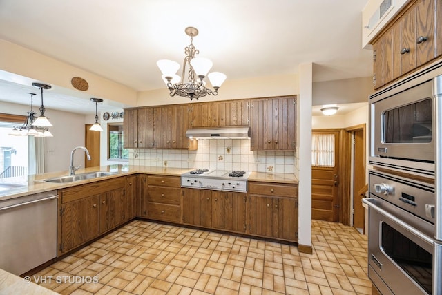 1707 N 78th Ave, Elmwood Park, IL 60707 - kitchen with appliances with stainless steel finishes, a chandelier, under cabinet range hood, light countertops, and decorative backsplash