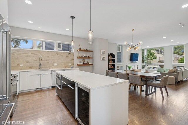 1633 N Saint Louis Ave, Chicago, IL 60647 - kitchen with healthy amount of natural light, decorative backsplash, wine cooler, wood finished floors, and recessed lighting