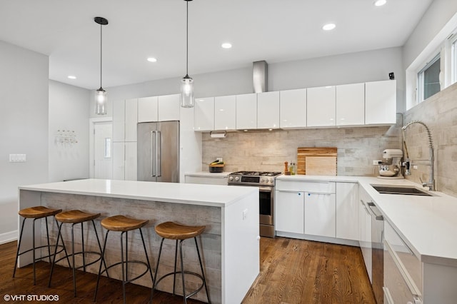 1633 N Saint Louis Ave, Chicago, IL 60647 - kitchen featuring appliances with stainless steel finishes, dark wood-style floors, backsplash, a kitchen island, and recessed lighting