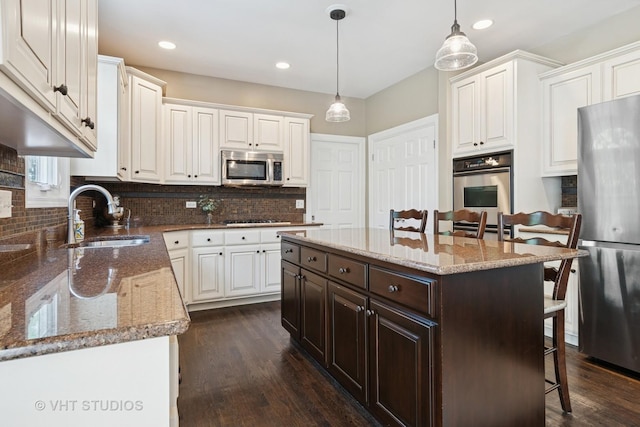 3136 Kewanee Ln, Naperville, IL 60564 - kitchen featuring appliances with stainless steel finishes, a breakfast bar, dark brown cabinetry, white cabinets, and recessed lighting