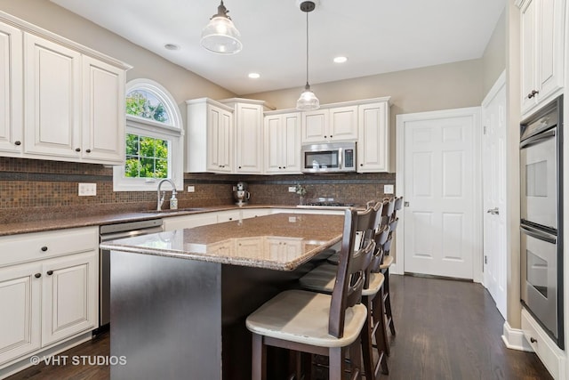 3136 Kewanee Ln, Naperville, IL 60564 - kitchen featuring appliances with stainless steel finishes, tasteful backsplash, stone counters, a center island, and a kitchen bar