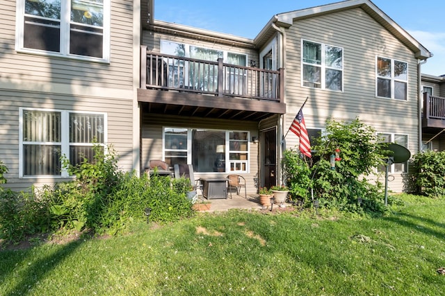 1022 Chaucer Ct Unit B, Elgin, IL 60120 - back of house featuring a balcony, a lawn, and a patio area