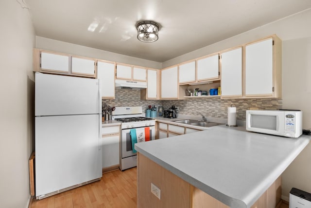 1022 Chaucer Ct Unit B, Elgin, IL 60120 - kitchen featuring white appliances, under cabinet range hood, a peninsula, tasteful backsplash, and light countertops