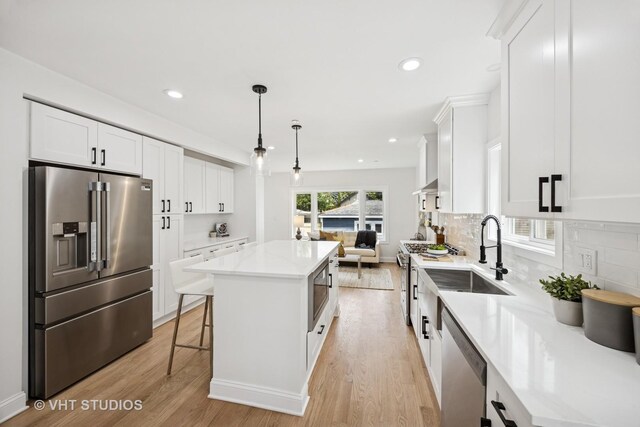 920 Hayes Ave, Oak Park, IL 60302 - kitchen featuring appliances with stainless steel finishes, a kitchen island, light wood-style flooring, white cabinets, and open floor plan